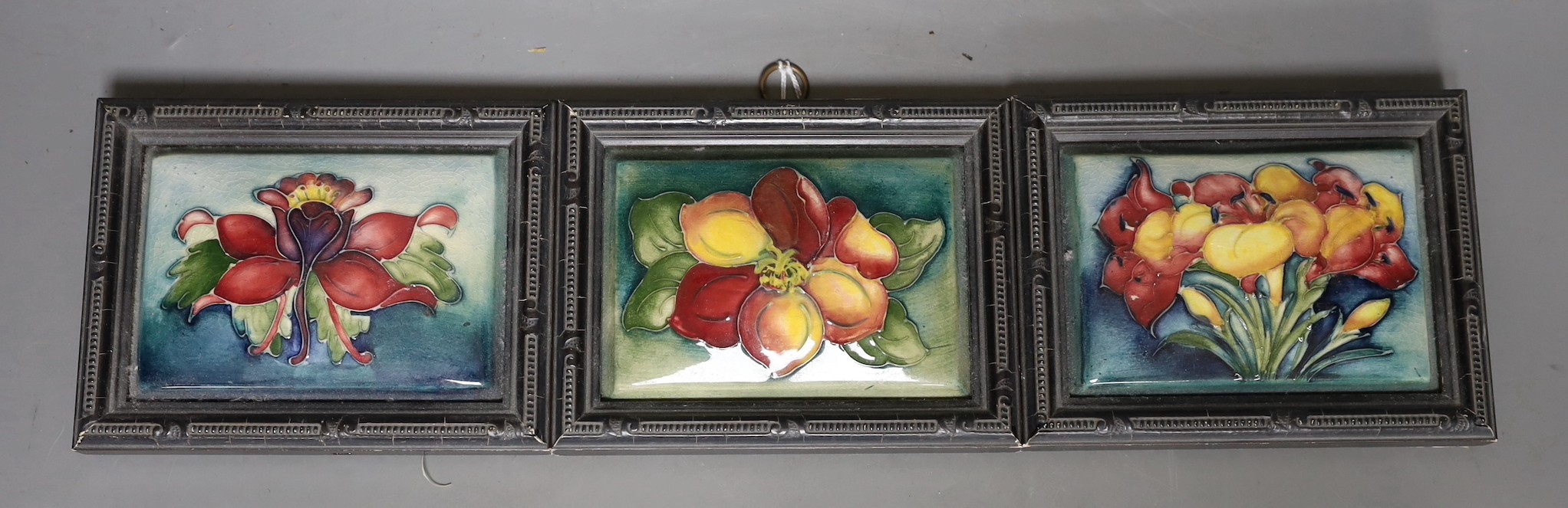 Three Moorcroft flower decorated plaques, impressed marks verso. 11.5 x 14cm